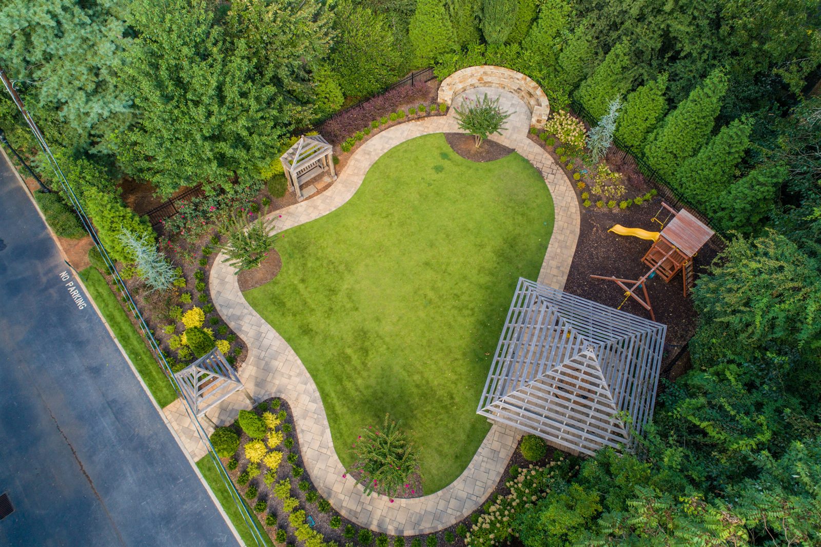 Aerial view of a fully maintained property with manicured turf and paver borders